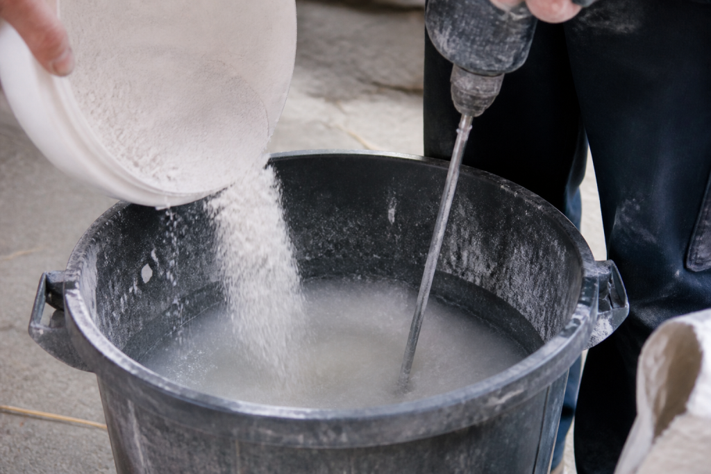 Poudre blanche versee dans eau avec melangeur electrique