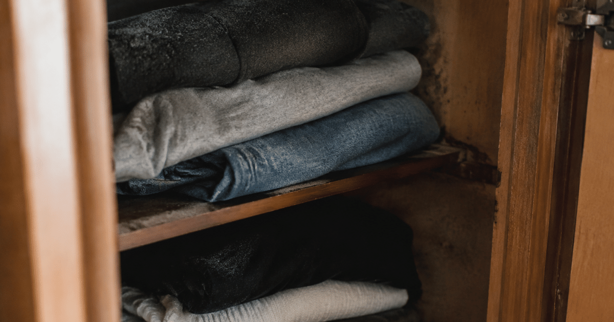 Vetements empiles sentant l'humidite dans placard ferme