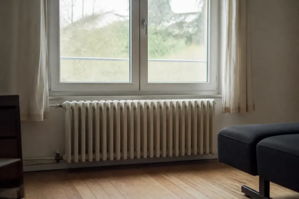 Radiateur en fonte sous une grande fenetre double vitrage
